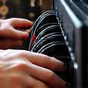 Technician carefully disconnecting cables from a high-end home theater system, documenting each connection.